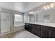 Bathroom featuring double vanity, white countertops, dark cabinets, a tub, and a glass enclosed shower at 2617 Romarin Ter, Henderson, NV 89044