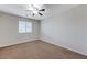 Empty bedroom featuring a ceiling fan, window and carpet floors, ready for customization at 2617 Romarin Ter, Henderson, NV 89044