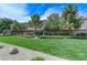 Lush green space with manicured lawn, mature trees, and walking path offer a serene and picturesque environment at 2617 Romarin Ter, Henderson, NV 89044