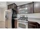 Modern kitchen featuring stainless steel appliances, dark cabinetry, and gray countertops at 2617 Romarin Ter, Henderson, NV 89044