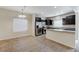 Open-concept kitchen featuring stainless steel appliances, dark cabinetry, and a tile floor at 2617 Romarin Ter, Henderson, NV 89044
