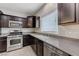 Modern kitchen featuring stainless steel appliances, dark cabinetry, and gray countertops at 2617 Romarin Ter, Henderson, NV 89044