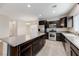 Modern kitchen featuring stainless steel appliances, dark cabinetry, and a kitchen island at 2617 Romarin Ter, Henderson, NV 89044