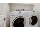 Laundry room showcases modern washer and dryer with neutral walls and access door at 2617 Romarin Ter, Henderson, NV 89044