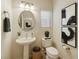 Chic powder room featuring a pedestal sink and modern decorative art at 2617 Romarin Ter, Henderson, NV 89044