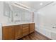 Bathroom with double sinks, wood cabinets, tub and tiled shower at 2682 Korea Ct, Henderson, NV 89052