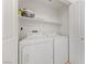 Bright laundry room features a white washer and dryer set, plus ample shelving for storage at 2682 Korea Ct, Henderson, NV 89052