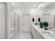 Bright bathroom featuring double sinks, quartz counters, and glass enclosed shower at 283 Fossil Falls St, Henderson, NV 89015