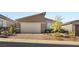 Inviting single-story home with a two-car garage, brick driveway, and desert landscaping at 283 Fossil Falls St, Henderson, NV 89015