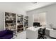 Bright office with a sleek white desk, built-in bookshelves and lots of natural light streaming through the window at 283 Fossil Falls St, Henderson, NV 89015