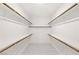 Walk-in closet features white shelving, wooden rods, and neutral flooring at 283 Fossil Falls St, Henderson, NV 89015