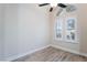 Bedroom with wood-look tile flooring, white walls, baseboards, ceiling fan, and natural light from windows at 289 Garwood Ct, Henderson, NV 89074