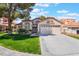 Charming single-story home with a well-manicured lawn, mature trees, and a two-car garage in a sunny neighborhood at 289 Garwood Ct, Henderson, NV 89074