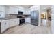 Modern kitchen with stainless steel appliances, white cabinetry, granite countertops, and wood-look tile flooring at 289 Garwood Ct, Henderson, NV 89074
