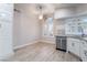 Kitchen with white cabinets, stainless steel dishwasher and sink, and wood-look tile flooring at 289 Garwood Ct, Henderson, NV 89074