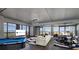 Modern living room with floor-to-ceiling windows, offering city views, complemented by a plush sectional and pool table at 4381 W Flamingo Rd # 5502, Las Vegas, NV 89103