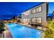 Beautiful backyard with a long pool, lounge area, and outdoor dining set up for entertaining guests at 472 Windstone Crest Ave, Las Vegas, NV 89138