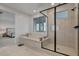 Bright bathroom featuring a soaking tub and glass-enclosed shower with sleek, modern finishes at 472 Windstone Crest Ave, Las Vegas, NV 89138
