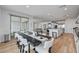 Bright dining area showcases a large dark wood table with white seating and stainless steel appliances in the background at 472 Windstone Crest Ave, Las Vegas, NV 89138