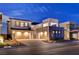 Contemporary two-story home features multi-car garage and professionally landscaped front yard at dusk at 472 Windstone Crest Ave, Las Vegas, NV 89138