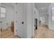 Hallway featuring wood floors, white walls, access to a powder room, and natural lighting at 472 Windstone Crest Ave, Las Vegas, NV 89138