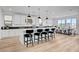 Open concept kitchen with white cabinets, modern pendant lighting, and a large island with seating at 472 Windstone Crest Ave, Las Vegas, NV 89138