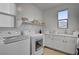 Well-equipped laundry room with modern appliances, storage shelves and counter space at 472 Windstone Crest Ave, Las Vegas, NV 89138