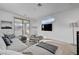 Comfortable living room with large sectional sofa, modern table, and balcony access at 472 Windstone Crest Ave, Las Vegas, NV 89138