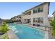 Modern home showcasing a pristine pool with lounge area, dining table, and a sleek, sun-drenched backyard at 472 Windstone Crest Ave, Las Vegas, NV 89138