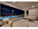 Outdoor patio with a covered seating area overlooking an illuminated pool at dusk at 472 Windstone Crest Ave, Las Vegas, NV 89138