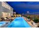 Backyard view features a long, illuminated swimming pool and manicured landscaping at 472 Windstone Crest Ave, Las Vegas, NV 89138