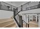 Contemporary staircase featuring wood steps, black metal railing, and white walls at 472 Windstone Crest Ave, Las Vegas, NV 89138