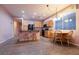 Open kitchen featuring wood cabinets, black appliances, and a breakfast bar with stools at 5332 Polo Grounds St, Las Vegas, NV 89148