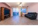 Cozy living room featuring tile floors, a media center, and sliding door access to the backyard at 5332 Polo Grounds St, Las Vegas, NV 89148