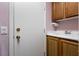 Laundry sink with wood cabinets, adjacent to the interior entry door to the house at 5332 Polo Grounds St, Las Vegas, NV 89148