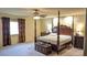 Spacious bedroom featuring a four-poster bed, ceiling fan, and plush carpeting for a comfortable retreat at 6339 Sharp Rock Ct, Las Vegas, NV 89139