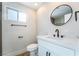 Modern bathroom with a white vanity, round mirror, and stylish fixtures at 6425 Evergreen Ave, Las Vegas, NV 89107