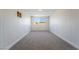 Bright bedroom with gray carpet, white walls, and a large window with a view to the outside at 6425 Evergreen Ave, Las Vegas, NV 89107