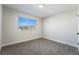 Comfortable carpeted bedroom with a large window for natural light and a view to the neighborhood at 6425 Evergreen Ave, Las Vegas, NV 89107