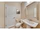 Powder room with pedestal sink, large mirror, and white toilet provides a convenient and stylish space at 6617 Fort William St, North Las Vegas, NV 89084