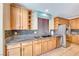 Bright kitchen features wood cabinetry, stainless steel appliances, tile backsplash, granite counters, and tile flooring at 6617 Fort William St, North Las Vegas, NV 89084