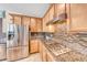 Modern kitchen with stainless steel appliances, granite countertops, gas range, and tile backsplash at 6617 Fort William St, North Las Vegas, NV 89084