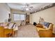 Cozy living room with a wood piano, bookshelves, a leather arm chair, and a ceiling fan, perfect for relaxation at 6617 Fort William St, North Las Vegas, NV 89084