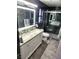 Beautiful bathroom featuring double sinks, modern vanity, and marble tiling in walk-in shower at 7091 Rhapsody Ln, Las Vegas, NV 89119
