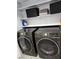 Laundry room featuring front loading, dark colored Samsung washer and dryer on light tile floor at 7091 Rhapsody Ln, Las Vegas, NV 89119