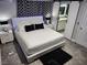 Stylish main bedroom featuring modern decor, a white bed frame, and an ensuite bathroom entrance at 7091 Rhapsody Ln, Las Vegas, NV 89119