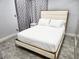 Bright bedroom features a light-colored upholstered bed frame and tile floors at 7091 Rhapsody Ln, Las Vegas, NV 89119
