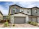 Attractive townhome featuring a two-car garage, stone detailing, and modern architecture, offering desirable curb appeal at 712 Monroe Hill Pl, Henderson, NV 89011