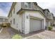 Two-story home featuring a large two-car garage with stone veneer accents and neutral color palette at 712 Monroe Hill Pl, Henderson, NV 89011