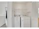 Laundry area featuring modern, white washer and dryer, plus storage shelving at 7222 Liberty Pride St, Las Vegas, NV 89148